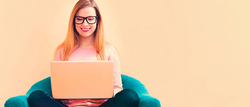 Top 8 Tips to Choose a Property Management Company 2 woman sitting cross legged looking at a laptop representing choosing property management company