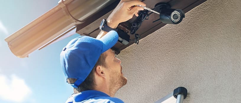 man fixing hoa security camera