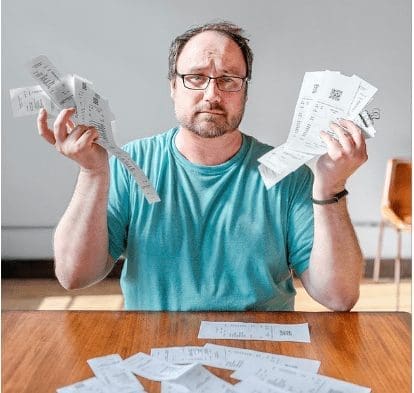 An image of a white man with bills and receipts for HOA Maintenance in his hands.