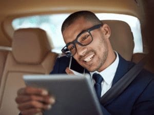 condo property manager - image of a man on the phone looking at a tablet in a car