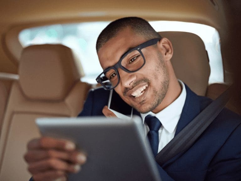 condo property manager - image of a man on the phone looking at a tablet in a car