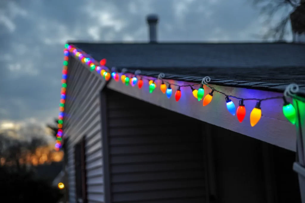 HOA Holidays: Top Best Practices 1 HOA Holidays: A house adorned with vibrant Christmas lights on its roof.