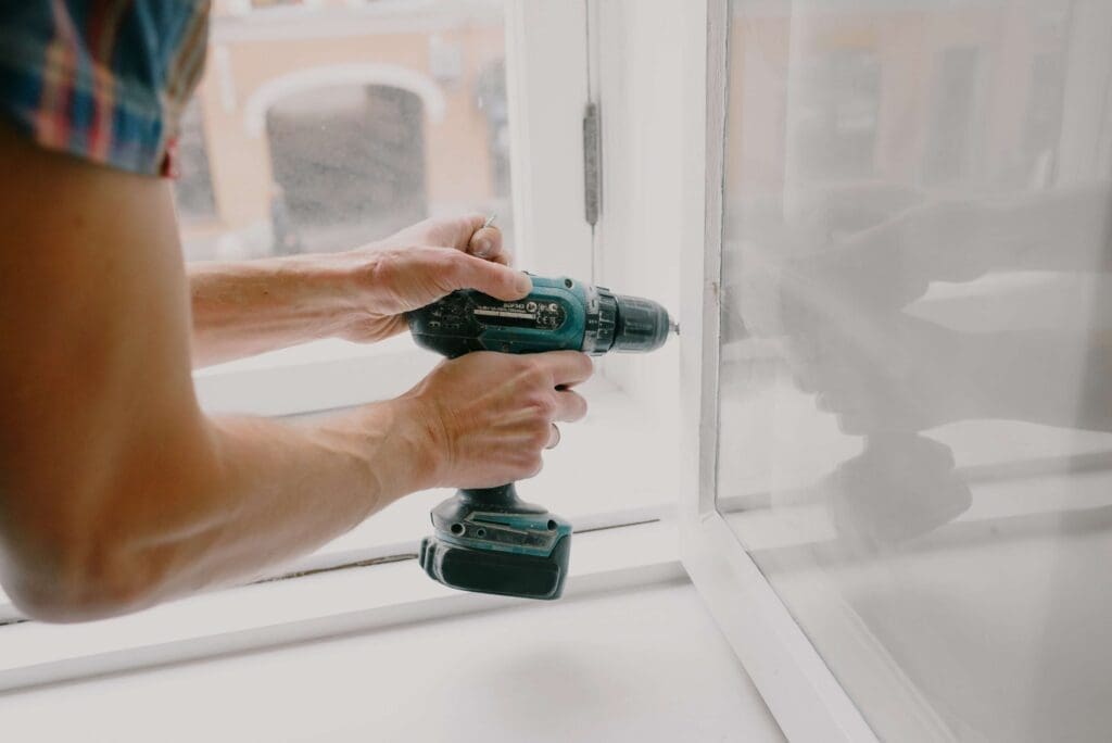 Service Requests: Best Practices for HOAs & Condos 1 service request - person fixing white window frame with a drill