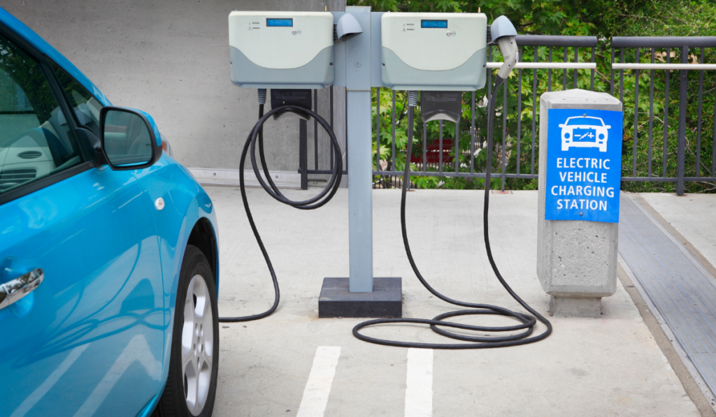 6 Ways To Become A More Eco-Friendly HOA 1 Blue car charging at an electric vehicle charging station