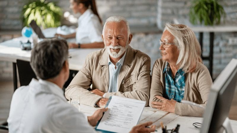 An old married couple talking to an expert about HOA Insurance in Florida. 