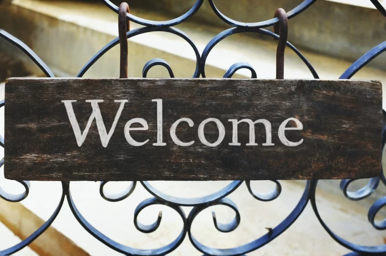 Image of a grid made of metal bars with a sign that reads 'Welcome.' This image represents the HOA Welcome Packet, symbolizing a warm and inviting reception