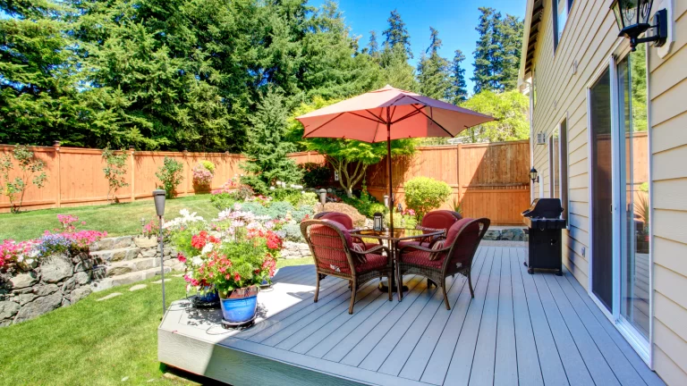 HOA backyard rules: Image of a tidy backyard with trimmed grass, flower beds, and a patio