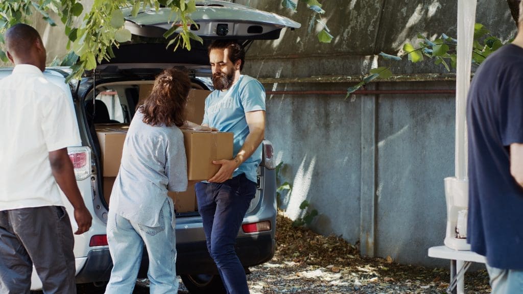 volunteers loading boxes into a car in daylight 2026 01 08 02 12 37 utc